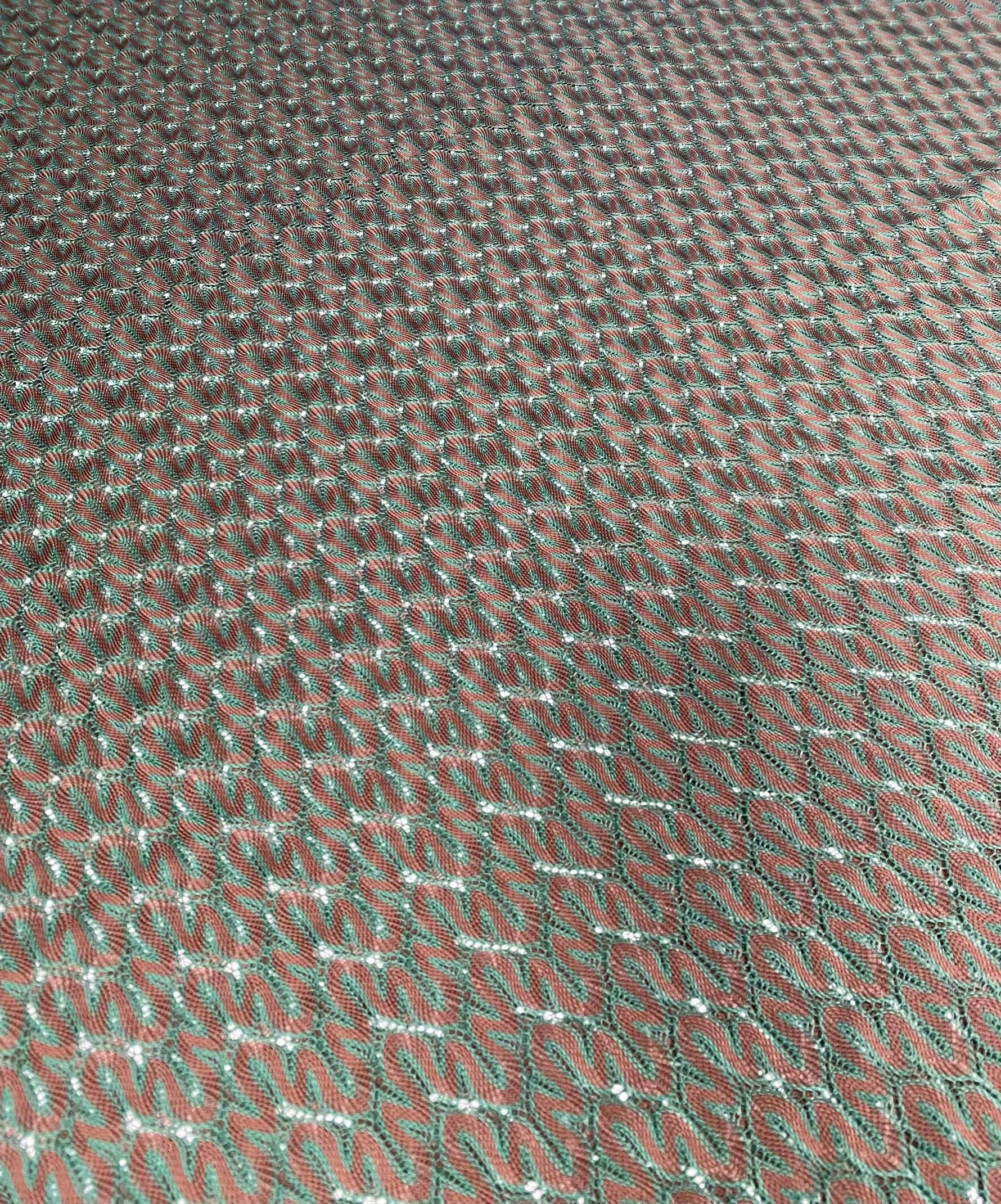 Green-brown woven mesh fabric with intricate texture for crafting and upholstery projects