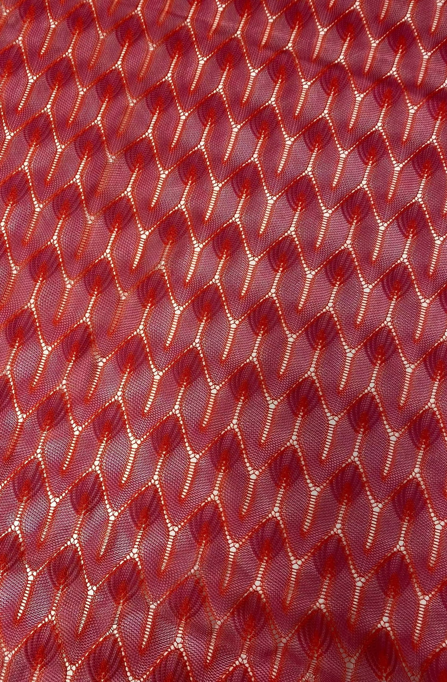 Close-up of red zigzag knit jersey fabric with soft stretchy texture for apparel and crafts