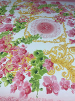 Orchid swirl print fabric with pink orchids, green leaves, and golden decorative swirls on a white background