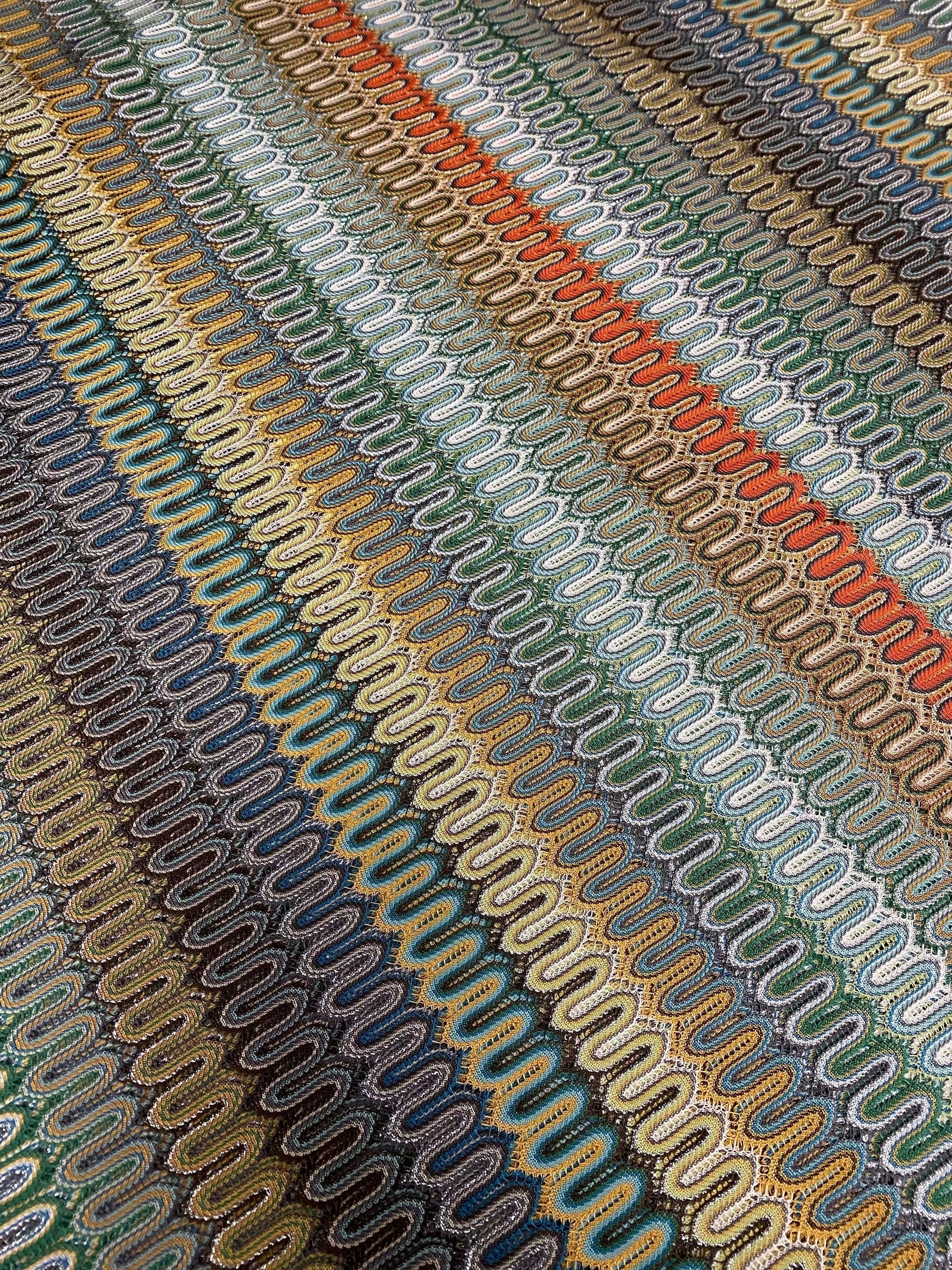 Colorful mesh zigzag knit fabric with a breathable, lightweight texture ideal for fashion and crafting projects
