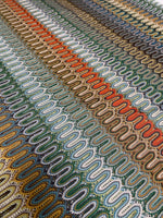 close-up of colorful mesh zigzag knit fabric with varied zigzag patterns in multiple colors and breathable texture
