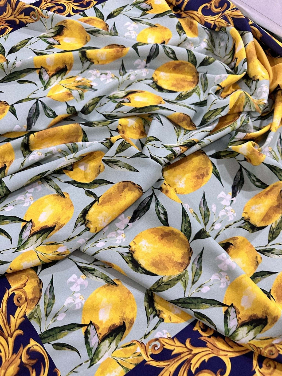 Baroque lemon fabric with Sicilian lemon and leaf pattern on light background with ornate navy border