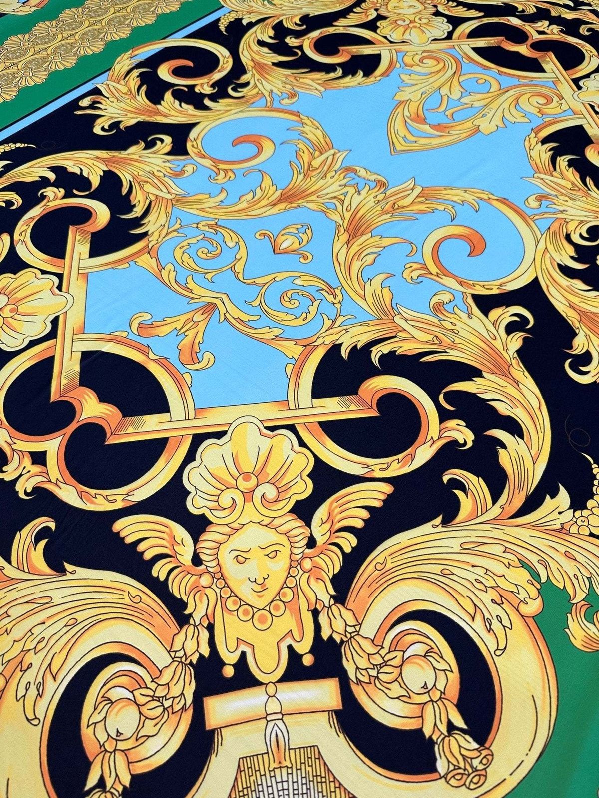 Baroque silky crepe fabric with intricate gold baroque patterns on blue and black background