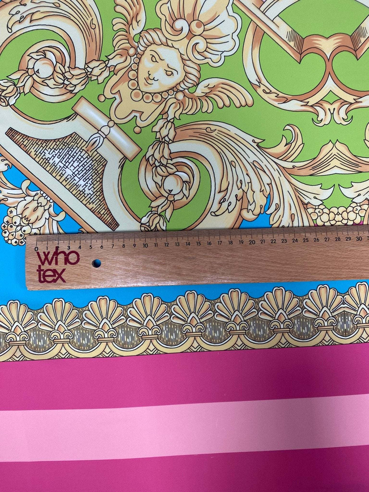 Baroque pink silky crepe fabric panel with ornate gold and green baroque design and pink striped border, 150cm width with ruler for scale