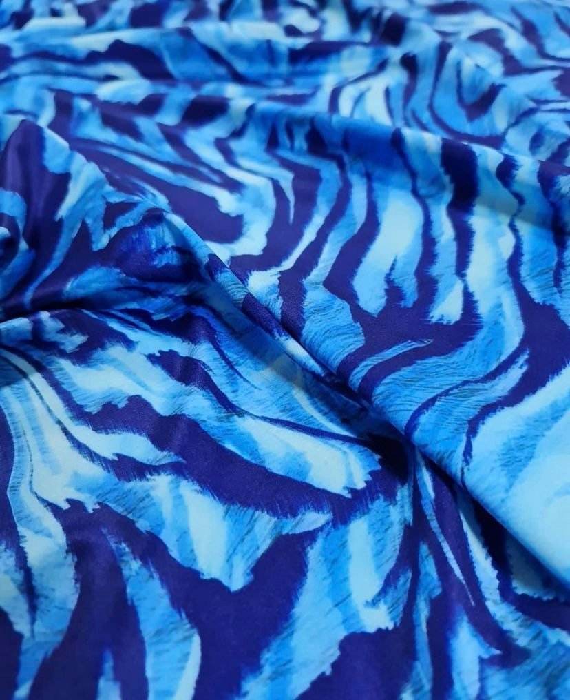 Close-up of durable blue zebra print fabric with vibrant stripes for sewing projects