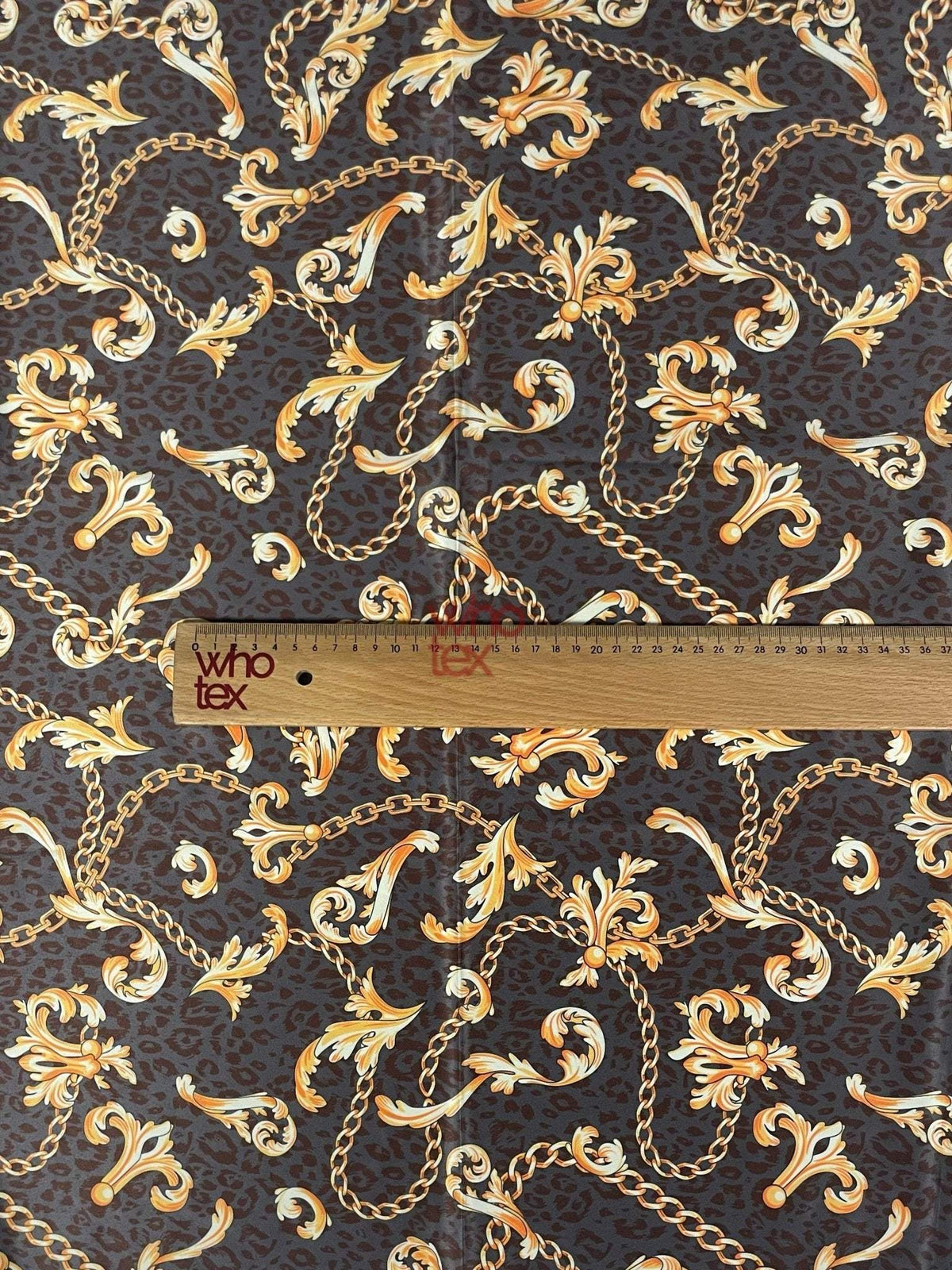 brown leopard print fabric with gold baroque chains and decorative scrolls with ruler for scale