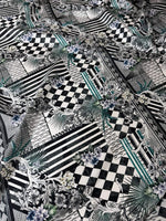 Checkerboard patchwork fabric with black and white geometric patterns and floral accents for quilting and home decor projects