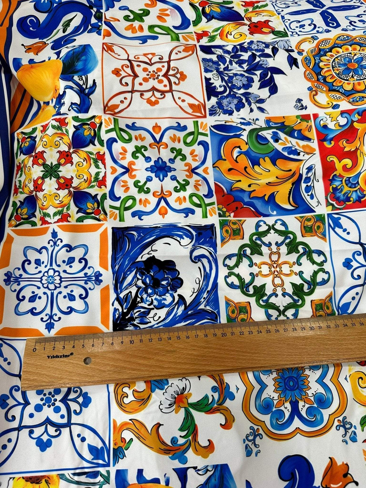 Colorful Sicilian print silky crepe fabric with intricate tile patterns and a ruler for scale