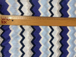 Blue, purple, and beige geometric zigzag patterned woven fabric with ruler for scale