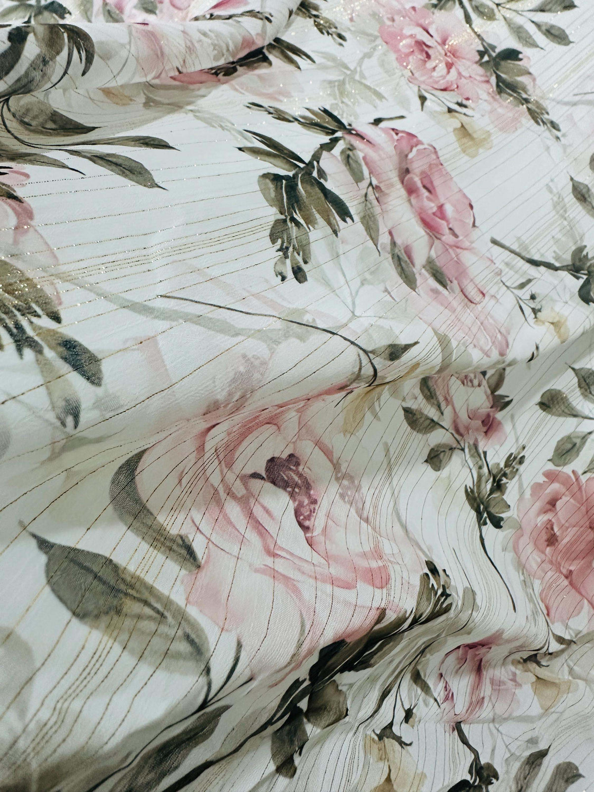 Lightweight chiffon fabric with gold striped floral print featuring pink roses and green leaves