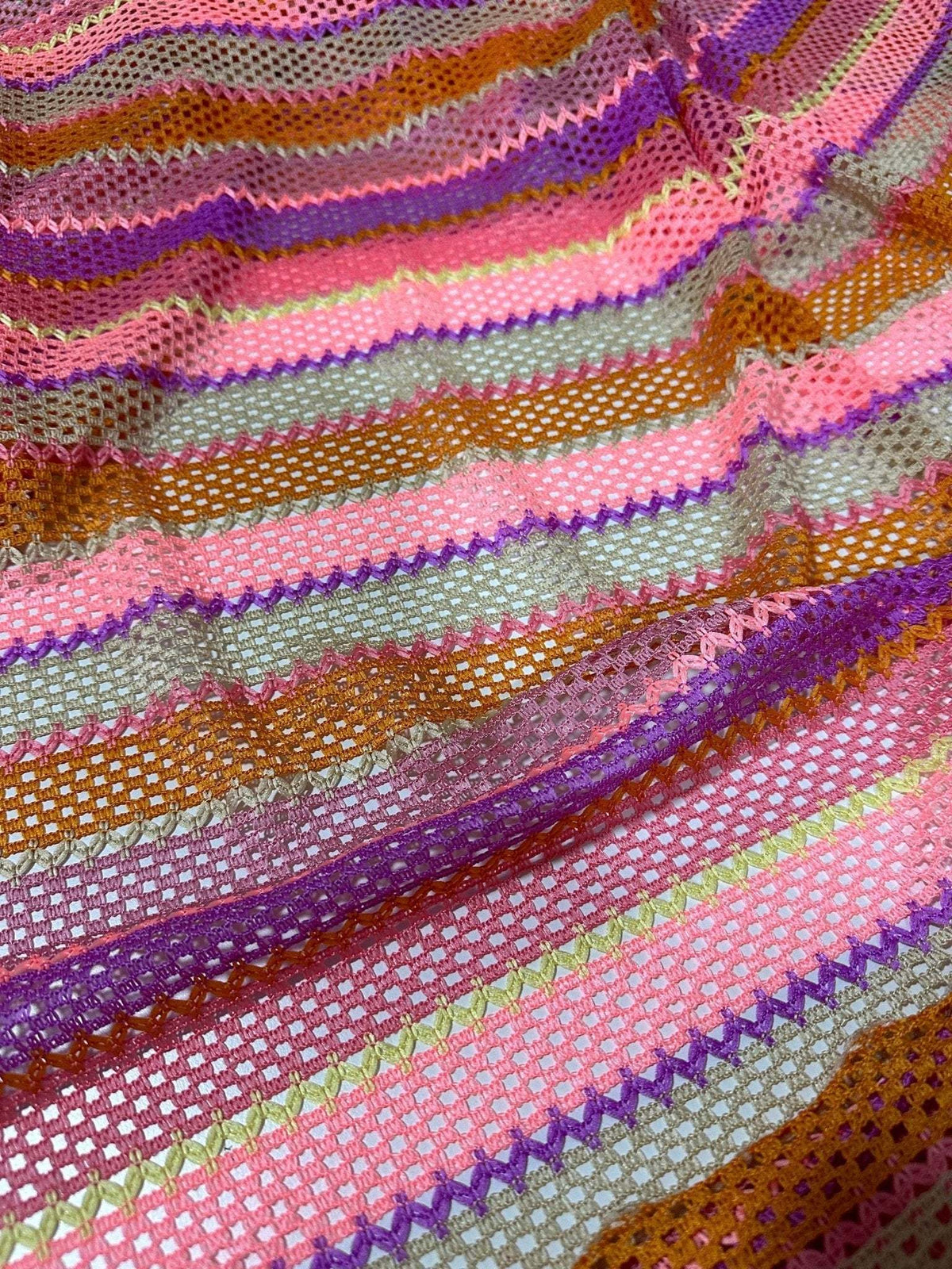 Pink striped knit jersey fabric with mesh texture in vibrant colors including pink, purple, brown, and green stripes.