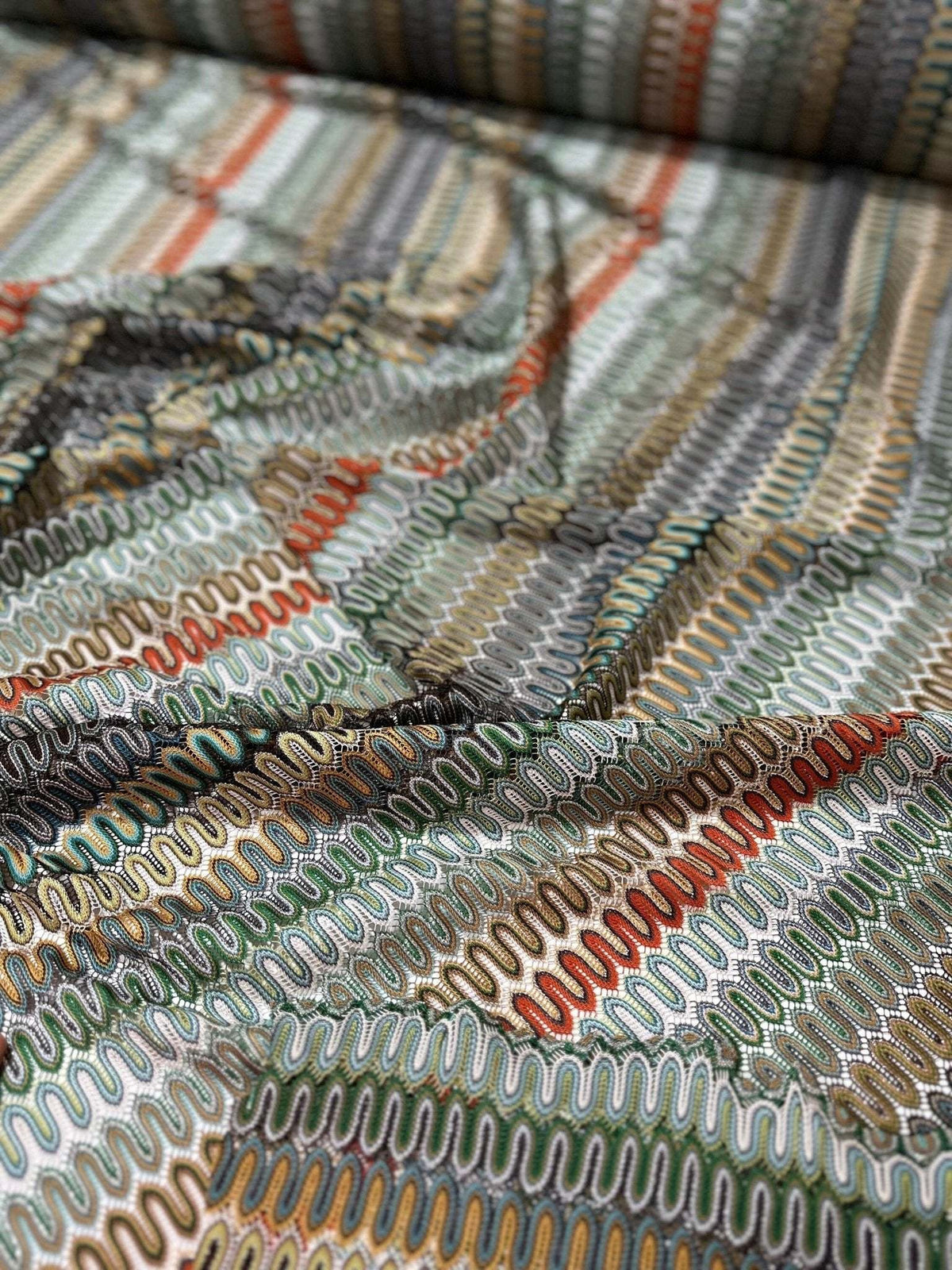 close-up of mesh zigzag knit jersey fabric with multicolor pattern and textured surface