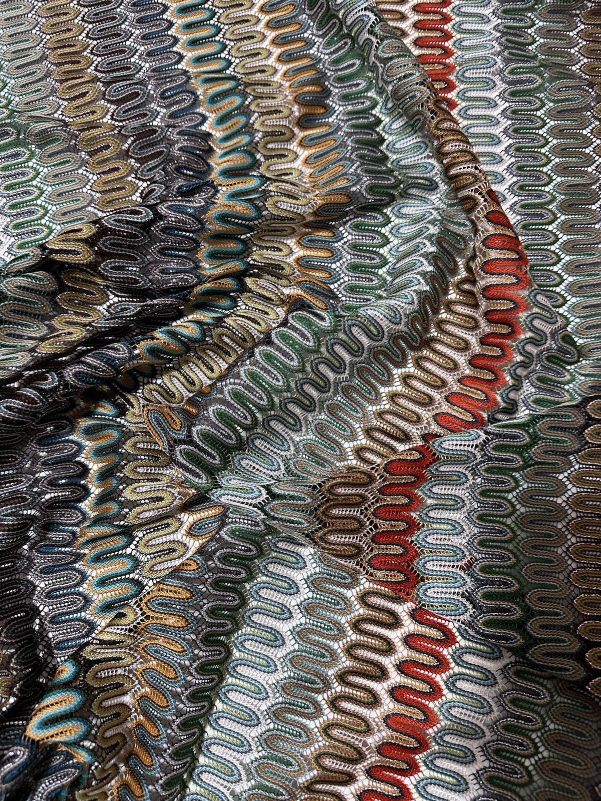 close-up of colorful mesh zigzag knit jersey fabric with textured pattern and waves