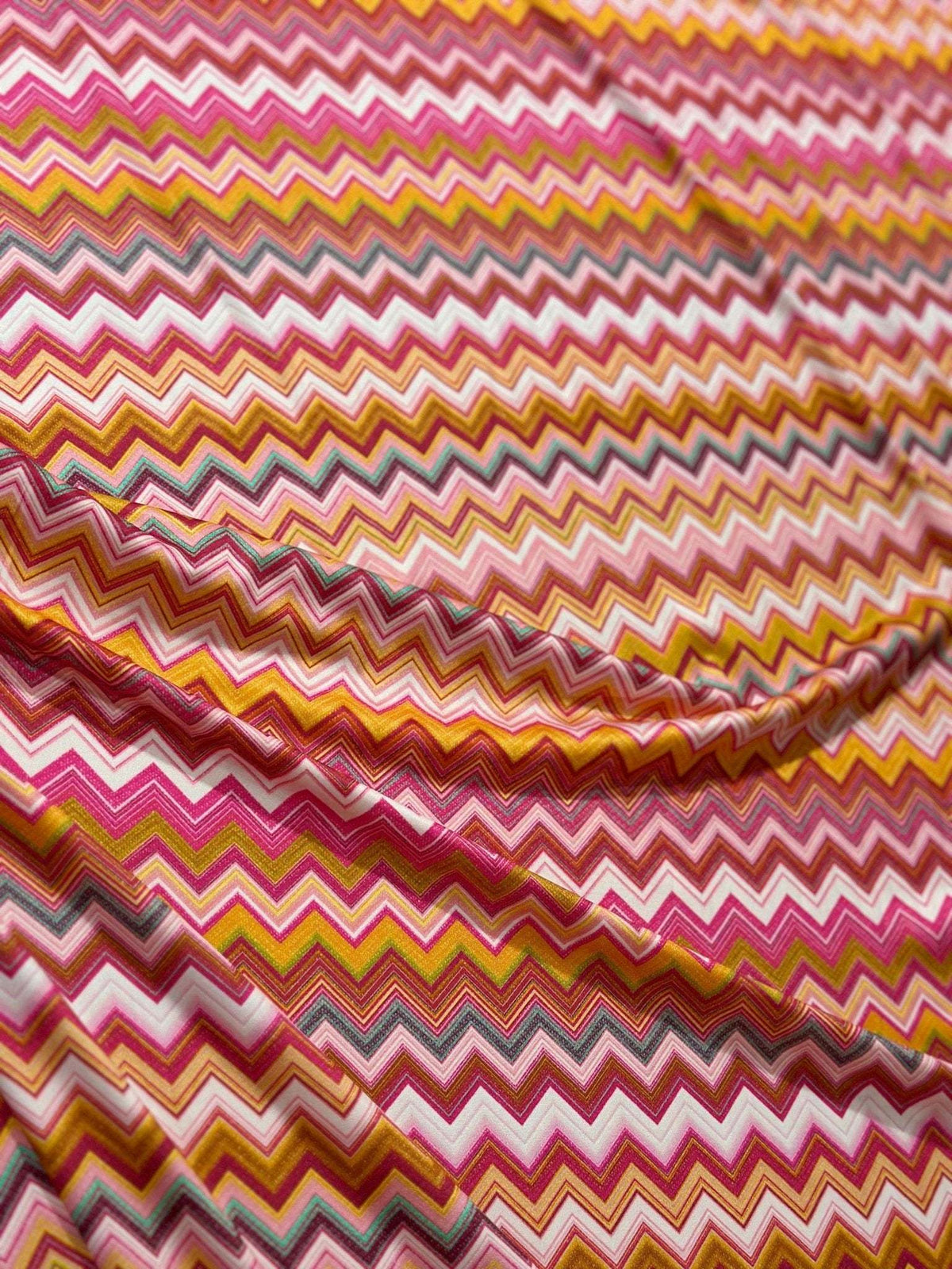 Close-up of colorful zigzag pattern fabric with 4-way stretch and 150cm width for versatile use