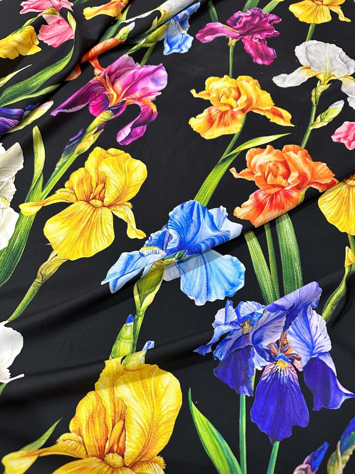 Floral crepe fabric with vibrant multicolor flowers on a black background, lightweight and soft for sewing projects