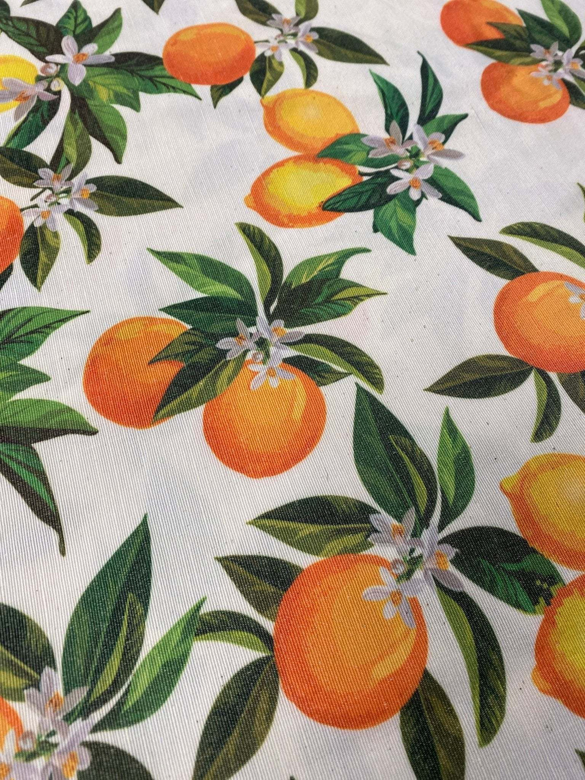 Orange linen fabric with vibrant orange fruit and green leaf pattern for crafting and home decor projects