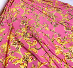 Pink and gold Baroque print fabric with ornate floral and scroll designs, ideal for upholstery and decorative projects