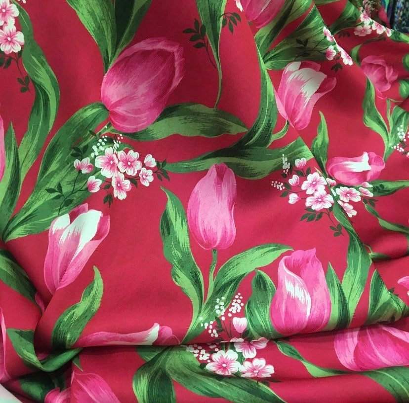 Pink tulip fabric with vibrant red background and green leaves floral pattern