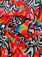 Close-up of vibrant rainbow abstract print fabric with bold red, black, and multicolor patterns, 150cm wide textile for sewing and crafting projects