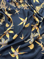 Black luxury fabric with yellow sea shell and starfish pattern on rich black background