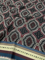 Burgundy and black geometric patterned fabric with ethnic striped border design