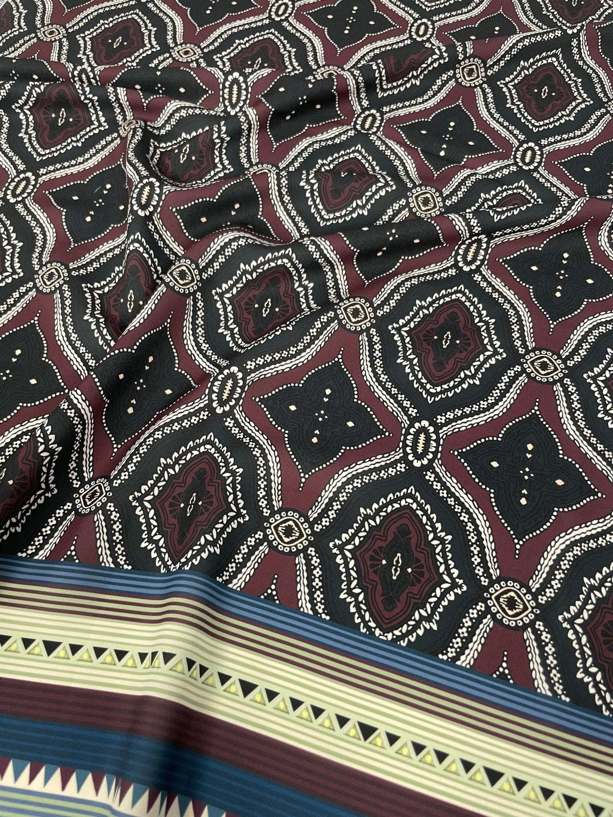 Burgundy and black geometric patterned fabric with ethnic striped border design