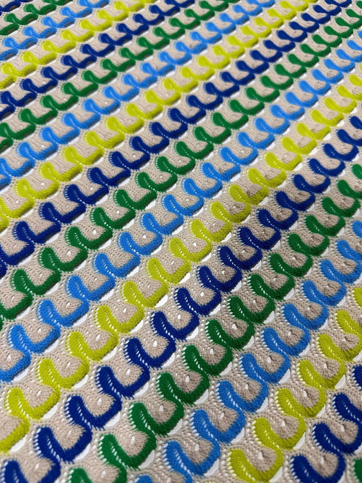 Luxury zigzag knit jersey fabric with blue, yellow, and green chevron pattern in soft textured knit